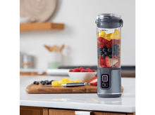 Charger l&#39;image dans la galerie, Un blender Ninja avec des fruits à l&#39;intérieur. Fraises, myrtilles, framboises et ananas sur une surface blanche.
