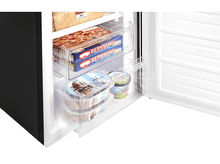 Charger l&#39;image dans la galerie, À l&#39;intérieur d&#39;un congélateur avec des aliments surgelés. Il y a des pots de crème glacée et des boîtes de pizza surgelées.
