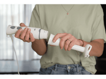 Charger l&#39;image dans la galerie, Une personne assemble un mixeur plongeant blanc. La personne porte une chemise verte et un jean. Le fond est flou.
