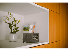 Charger l&#39;image dans la galerie, Gros plan d&#39;une étagère dans un meuble en bois avec une radio, des livres et des fleurs.
