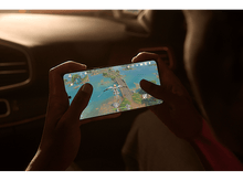 Charger l&#39;image dans la galerie, Personne tenant un téléphone jouant à un jeu. L&#39;écran montre un paysage avec un personnage.
