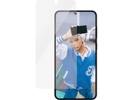 Une personne tenant un téléphone noir. Un protecteur d'écran est placé à côté du téléphone. La personne porte une veste bleue.