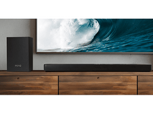 Charger l&#39;image dans la galerie, Une barre de son et un caisson de basses noirs sur un meuble en bois, avec TV.
