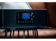 Charger l&#39;image dans la galerie, Une radio noire avec un écran affichant une horloge, sur une table noire.
