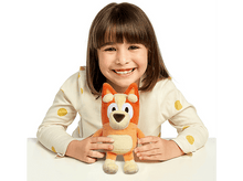 Charger l&#39;image dans la galerie, Jeune fille sourit, tenant une peluche orange et beige d&#39;un personnage de dessin animé.

