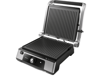Un grill électrique ouvert avec une surface de cuisson noire et nervurée et un cadre argenté. Le grill est sur une surface noire.