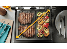 Charger l&#39;image dans la galerie, Gril avec deux steaks et légumes grillés. Flèche indique la zone de cuisson.

