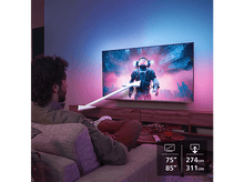 Charger l&#39;image dans la galerie, Homme regardant la télévision avec une scène d&#39;astronaute et du texte sur la taille de l&#39;écran.
