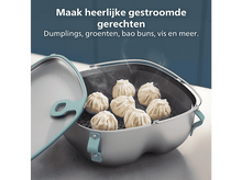 Charger l&#39;image dans la galerie, Des raviolis à la vapeur dans un cuiseur vapeur argenté. Le couvercle est ouvert. L&#39;arrière-plan montre un mur bleu et le texte &#39;Dumplings, légumes, pains bao, poisson et plus&#39;.
