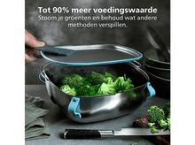 Charger l&#39;image dans la galerie, Un cuiseur vapeur en acier inoxydable avec du brocoli, de la vapeur s&#39;élève. Une personne soulève le couvercle. Un couteau et une planche à découper sont à proximité.
