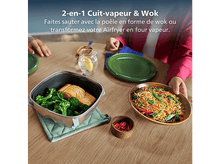 Charger l&#39;image dans la galerie, Une table avec de la nourriture : brocoli et saumon, nouilles et piments. Une personne tient une assiette de nouilles.
