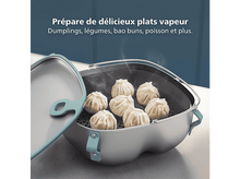 Charger l&#39;image dans la galerie, Cuit-vapeur avec raviolis, vapeur s&#39;élevant. Couvercle partiellement ouvert. Texte : Préparez de délicieux plats vapeur.
