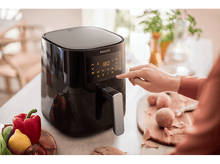Charger l&#39;image dans la galerie, Une main touche le panneau de commande d&#39;une friteuse à air. Légumes à gauche, pommes de terre à droite, sur des planches.
