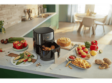 Charger l&#39;image dans la galerie, Friteuse à air noire avec aliments, entourée d&#39;aliments cuits et frais sur un comptoir de cuisine.
