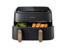 Charger l&#39;image dans la galerie, Une friteuse à air Philips noire avec deux compartiments, l&#39;un avec des légumes verts et l&#39;autre avec du saumon cuit.
