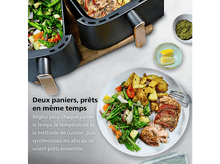 Charger l&#39;image dans la galerie, Une friteuse à air avec deux paniers, l&#39;un avec des légumes, l&#39;autre avec de la nourriture. Une assiette contient de la nourriture, des tranches de citron et du pesto.
