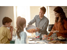 Charger l&#39;image dans la galerie, Une famille mange ensemble, le père sert des frites aux enfants.
