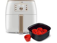 Une friteuse à air Philips blanche et dorée avec un panier noir et des moules à muffins en silicone rouge.