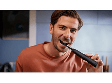 Charger l&#39;image dans la galerie, Homme se brossant les dents avec une brosse à dents électrique noire. Souriant.
