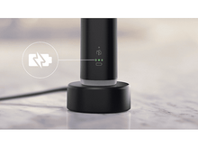 Charger l&#39;image dans la galerie, Une base de chargement noire avec un symbole de chargement et des lumières LED vertes est sur une surface.
