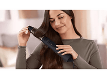 Charger l&#39;image dans la galerie, Une femme se coiffant avec un styler capillaire noir et doré.
