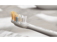 Charger l&#39;image dans la galerie, Gros plan d&#39;une brosse à dents avec des poils colorés, manche blanc.
