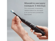 Charger l&#39;image dans la galerie, Une personne tenant une brosse à dents électrique noire. Le texte conseille de changer la tête tous les 3 mois.
