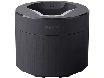 Station de charge pour haut-parleur Philips noire. C'est un cylindre rond avec un dessus blanc.