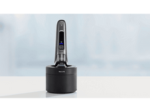 Charger l&#39;image dans la galerie, Un rasoir électrique Philips noir et argent dans son socle de chargement.
