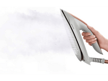 Charger l'image dans la galerie, Une personne repassant avec un fer à repasser Philips blanc et doré, vapeur visible.
