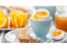 Charger l&#39;image dans la galerie, Oeuf à la coque dans un coquetier bleu, avec des toasts et des tranches d&#39;orange. Une cuillère près de l&#39;œuf.
