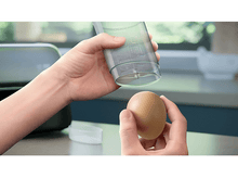 Charger l&#39;image dans la galerie, Mains tenant un récipient transparent et un œuf, préparant la cuisine.
