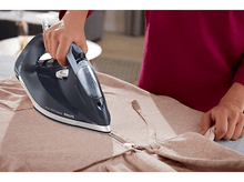 Charger l&#39;image dans la galerie, Personne repassant une veste. Fer à repasser bleu, veste rose sur une planche à repasser.
