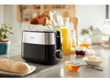 Charger l&#39;image dans la galerie, Un grille-pain avec un croissant dessus, à côté d&#39;un bol de miel et d&#39;autres aliments du petit-déjeuner.
