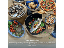 Charger l'image dans la galerie, Une table avec une variété d'aliments : pizza, poisson, steak, croissants et une tarte. La nourriture est disposée sur des planches de bois et une assiette bleue.
