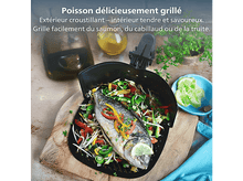 Charger l'image dans la galerie, Poisson grillé avec légumes dans un panier à griller, sur une planche en bois. Inclut une bouteille d'huile, des herbes et un bol de tranches de citron.
