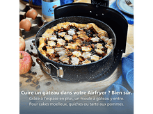Charger l'image dans la galerie, Tarte aux pommes dans un moule noir. Pommes et raisins secs éparpillés. Œufs et bouteille en arrière-plan.
