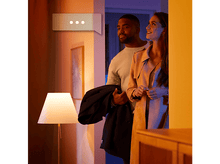 Charger l'image dans la galerie, Un couple dans une porte. L'homme tient un manteau. Une lampe est à gauche.
