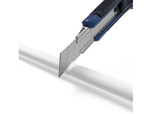 Charger l&#39;image dans la galerie, Un cutter coupant un tube en plastique blanc sur fond blanc. La lame est exposée.
