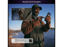 Charger l&#39;image dans la galerie, Homme regardant son téléphone, avec une incrustation d&#39;une personne à une porte. Scène en plein air. Ciel bleu et eau.
