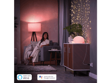 Charger l&#39;image dans la galerie, Une femme est assise sur une chaise avec une lampe. Les logos Alexa et Google Assistant sont affichés.
