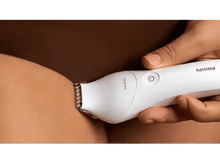 Charger l&#39;image dans la galerie, Une main tient une tondeuse Philips blanche, taillant une jambe. Elle est étiquetée &#39;Wet &amp; Dry&#39; et a un bouton d&#39;alimentation.
