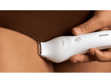 Charger l&#39;image dans la galerie, Main d&#39;une personne utilisant une tondeuse Philips blanche sur sa jambe. Vue rapprochée. Teinte de peau brune.
