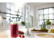 Charger l&#39;image dans la galerie, Un mixeur plongeant blanc est posé sur un comptoir, avec un verre de smoothie et des ingrédients à proximité.
