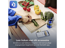 Charger l&#39;image dans la galerie, Une personne coupe des courgettes sur une planche en bois. Tomates, poivrons jaunes, courgettes et brocolis sont à proximité. Un téléphone affiche une recette.
