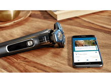 Charger l&#39;image dans la galerie, Un rasoir Philips et un smartphone affichant le guide de rasage avec des informations connexes.
