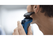 Charger l&#39;image dans la galerie, Un homme se rase le visage avec un rasoir Philips bleu et noir.
