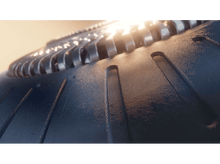 Charger l&#39;image dans la galerie, Gros plan d&#39;un pneu noir avec une jante argentée, texturé de petits points.
