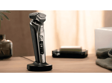 Charger l&#39;image dans la galerie, Rasoir électrique sur socle, métal brillant et noir. Savon et serviette à proximité.
