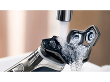 Charger l&#39;image dans la galerie, Rasoir électrique sous l&#39;eau courante. Le rasoir est ouvert pour montrer les composants internes.
